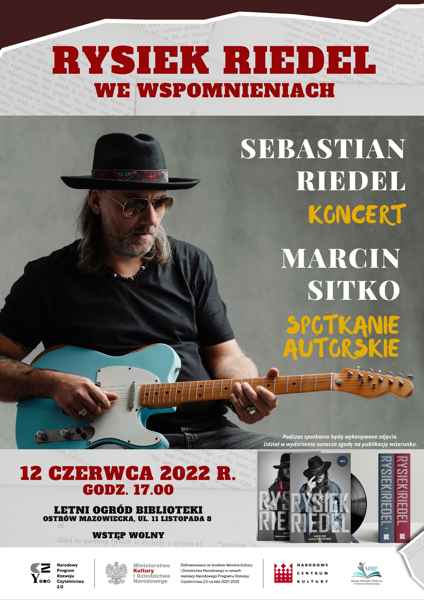 plakat zapraszający na koncert Ryszarda Riedla, który jest na plakacie i trzyma gitarę w ręku, Rysiek Riedel we wspomnieniach 12 czerwca 2022 roku godzina 17, Marcin sitko spotkanie autorskie w letnim ogrodzie biblioteki ul. 11 listopada 7 Ostrów Mazowiecka 