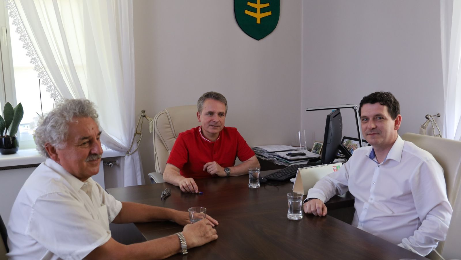 trzech mężczyzn siedzi przy stole