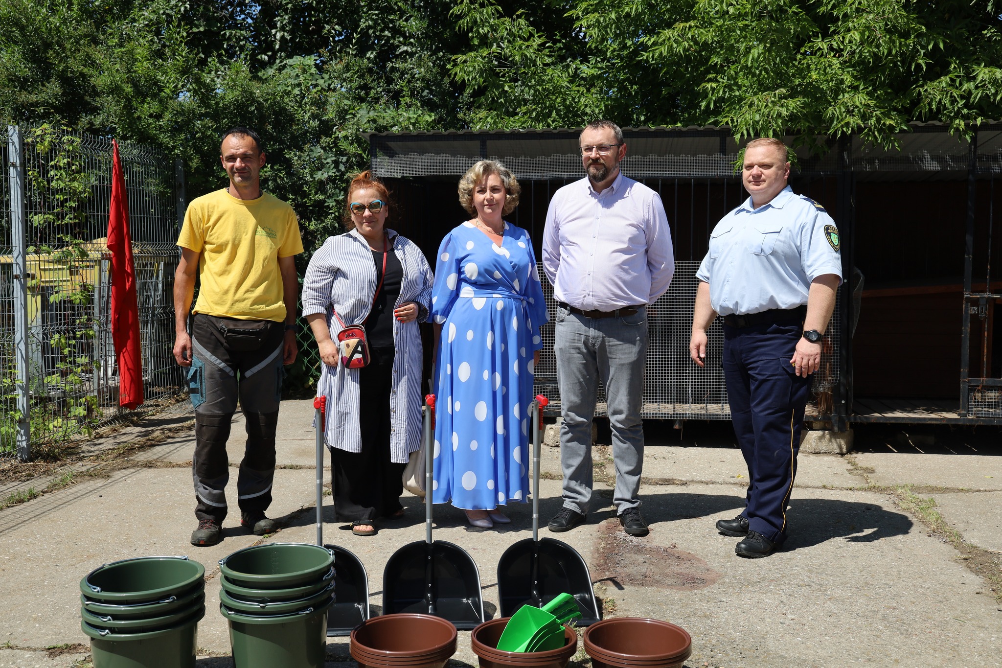 grupa osób stoi przed kojcami