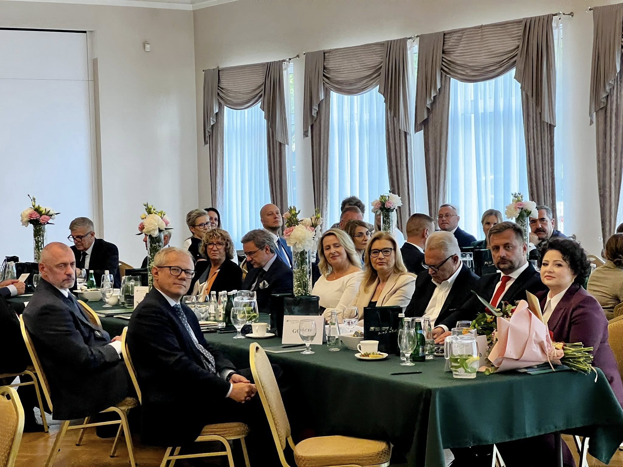 grupa osób siedzi przy stołach