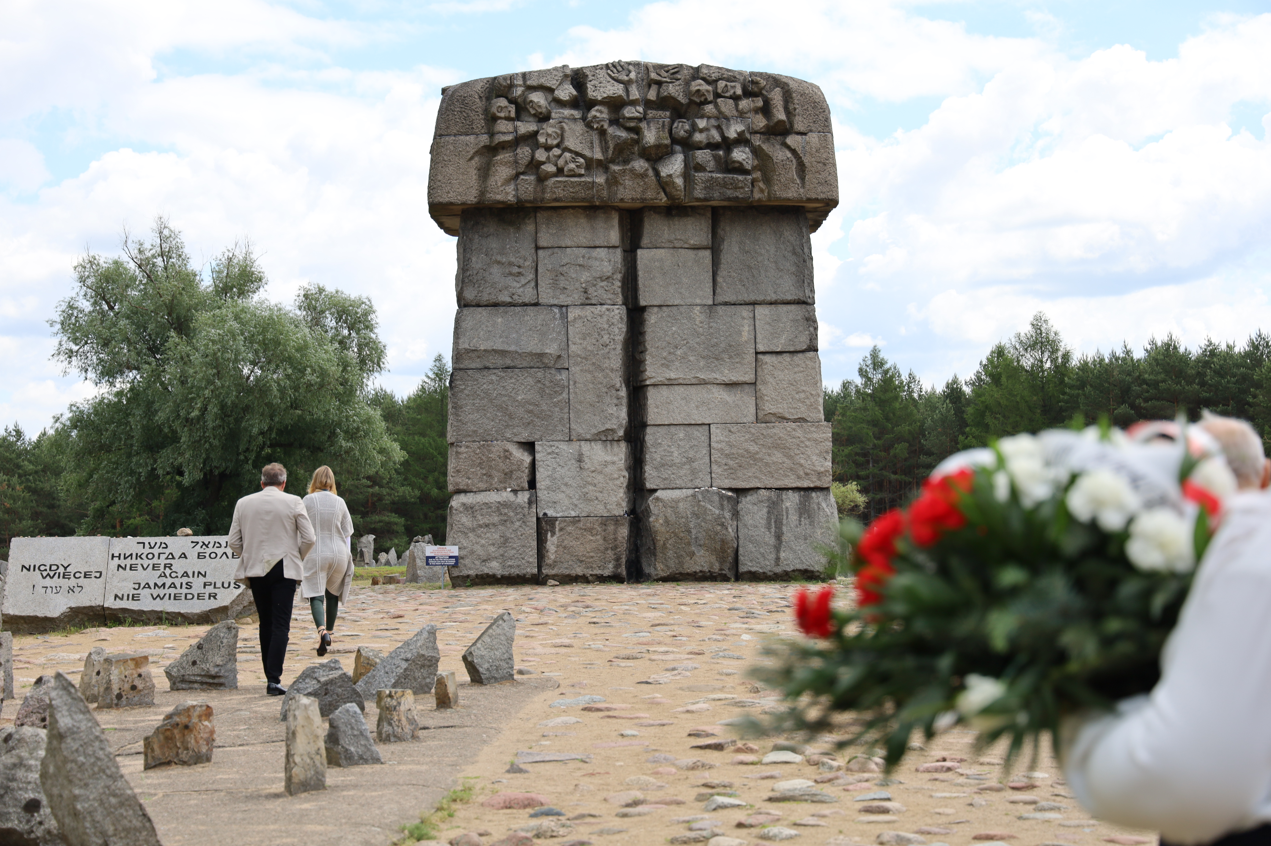Pomnik z kamienia w muzeum Treblinka , osoby składające kwiaty z okazji obchodu uroczystości 
