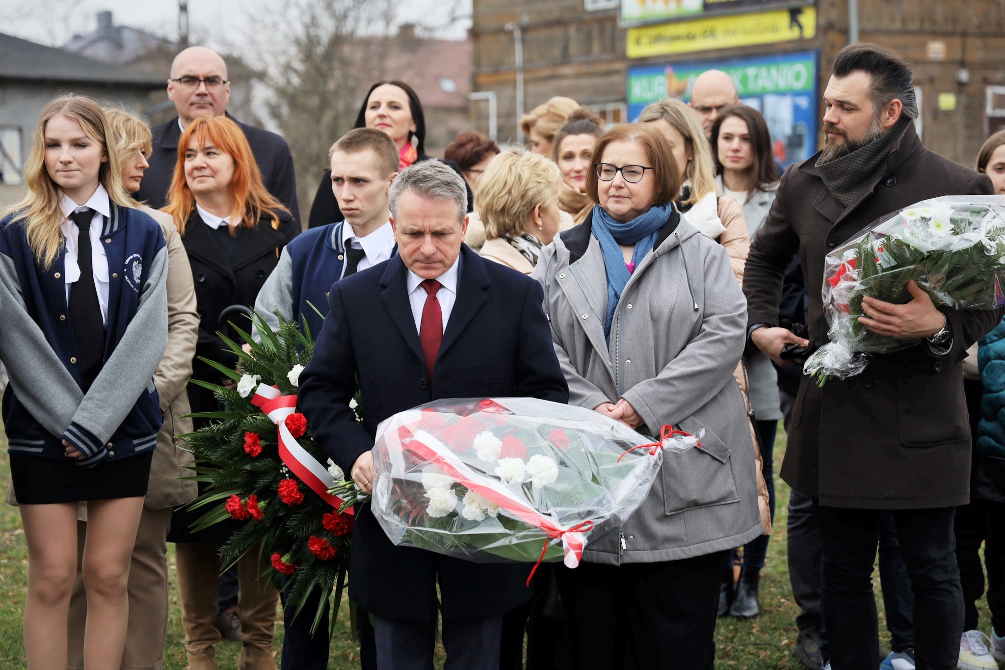 Uczestnicy uroczystości składają kwiaty