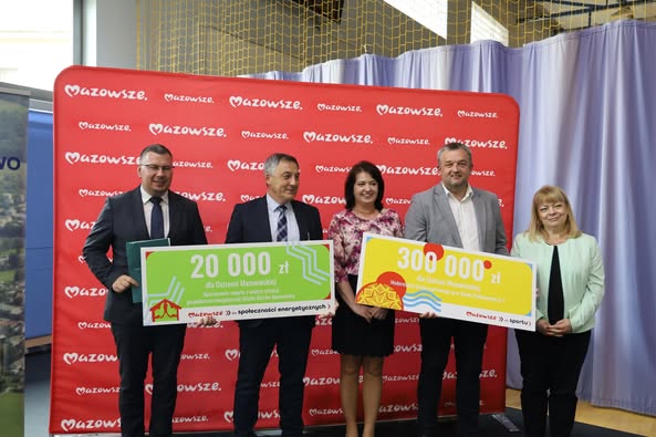 kobiety i mężczyźni trzymający czek na dofinasowanie