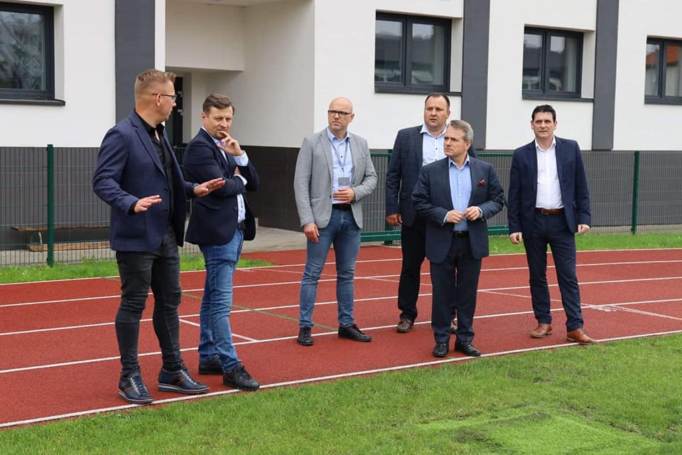 kilku mężczyzn stoi obok boiska