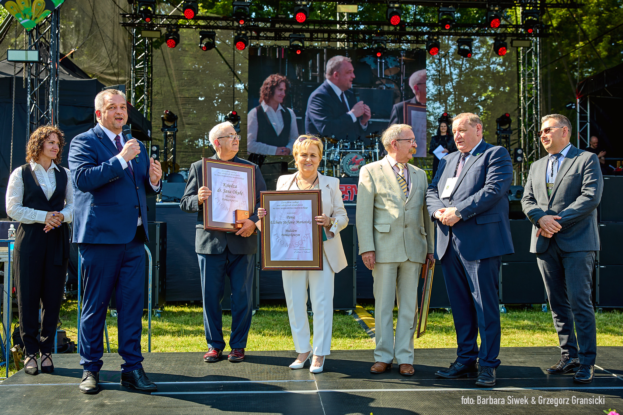 grupa osób pozuję do zdjęcia i pokazują dyplomy