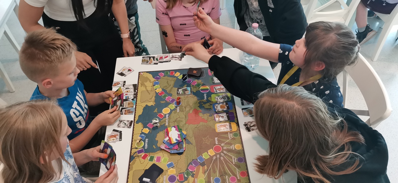 Uczestnicy świetlicy socjoterapeutycznej grają w grę planszową w muzeum dom rodziny Pileckich 